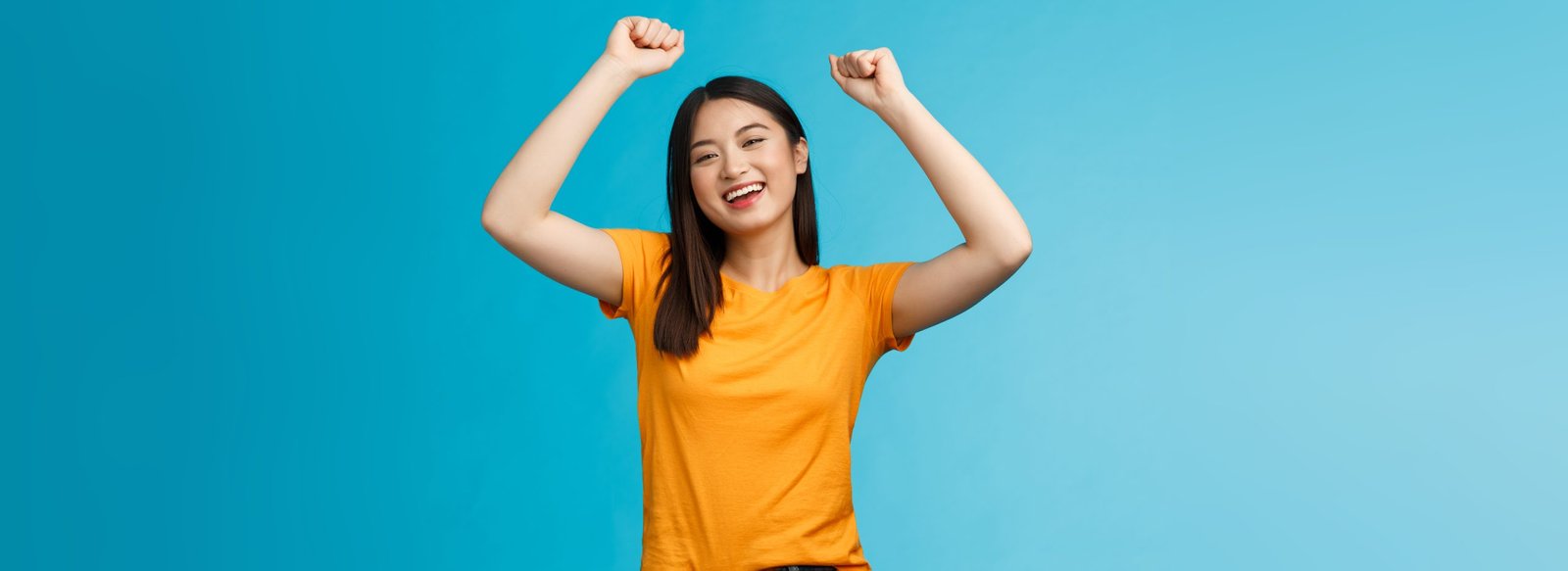 Cheerful happy optimistic cute asian girl raise hands fist pump, celebrating victory, cheering rooting for favorite team, smiling broadly support friend scored goal, achieve success, triumphing.